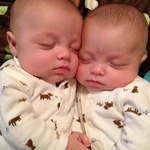 Sleepy babies holding hands