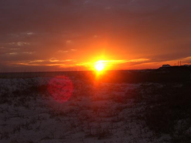 sun going down behind the dunes almost look like snow instaed of sand