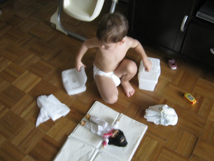 Changing his doll's diaper