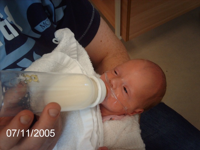 daddy feeding erin in HDU, about 6 weeks old, getting better