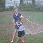 Two of my grandkids cooling down with the sprinkler