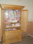 armoire with a bunch of baby clothes !