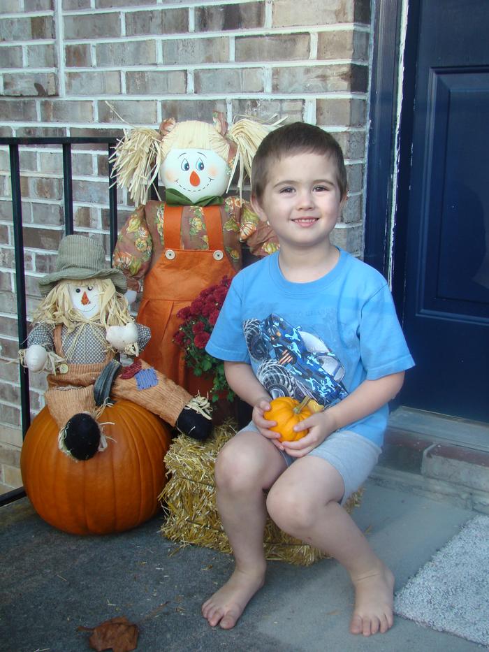 Mason posing with some of fall decorations on porch. 10-2-08
