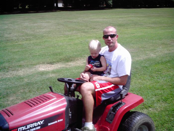 Gavin and Daddy mowing 