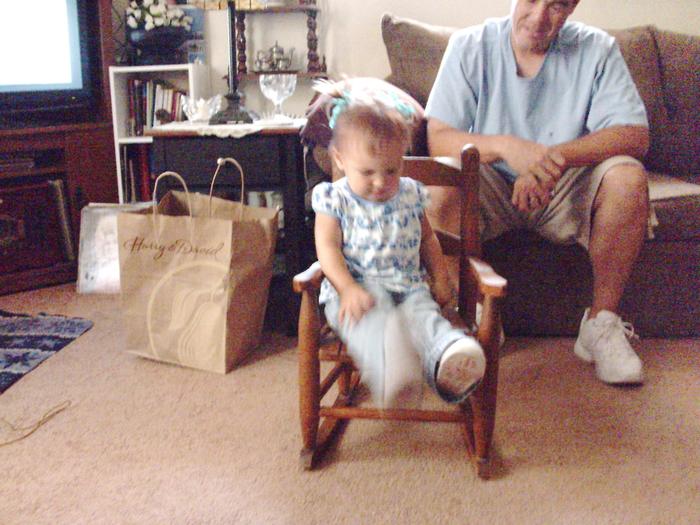 Meagan trying out the rocker that Grandma had as a little girl, Daddy looking on.